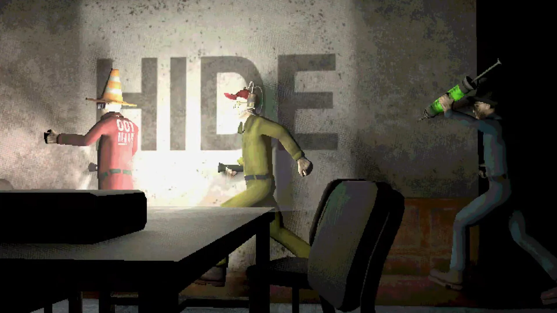 Machine Party in-game capture: a concrete wall with the word 'HIDE' painted in mirror lettering, three test subjects peeking out from behind it — one in red with a traffic-cone hat, one in yellow with an animal mask and a small firearm, one in blue holding a green vial — and a dark chair pulled up to the scene in the foreground.